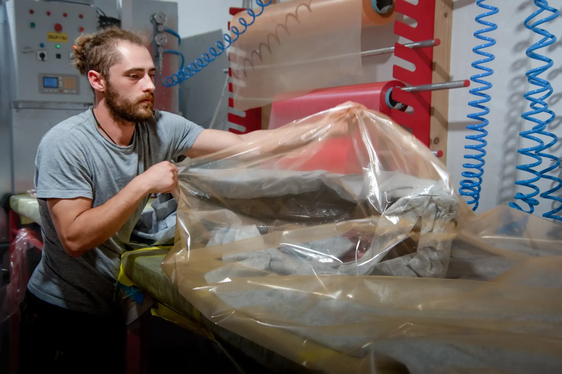 Un tecnico posiziona il film del sacco a vuoto attorno a uno stampo composito prima della polimerizzazione in autoclave